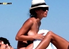 Hot young nudist brunette enjoys a sunny day on the beach